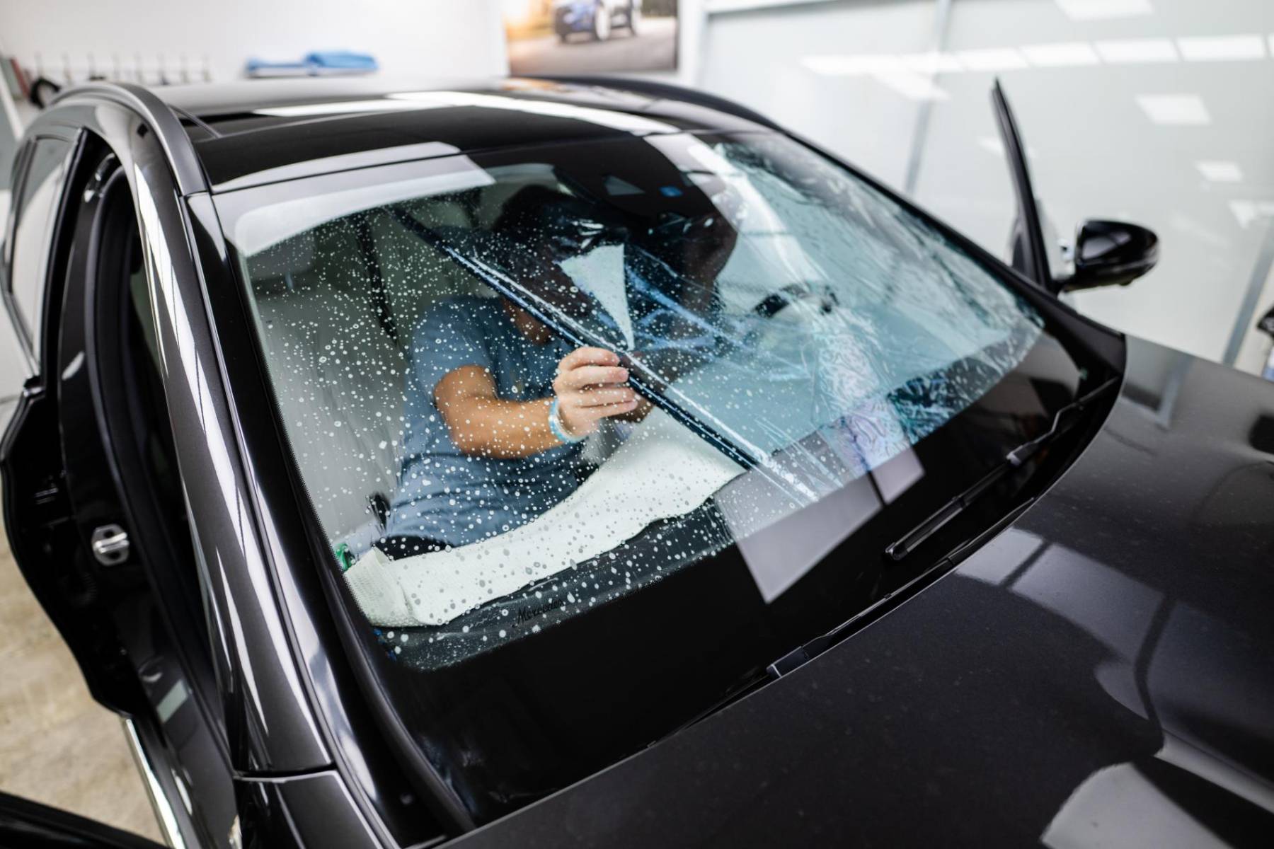 Ceramic film being installed on a windshield at Sage